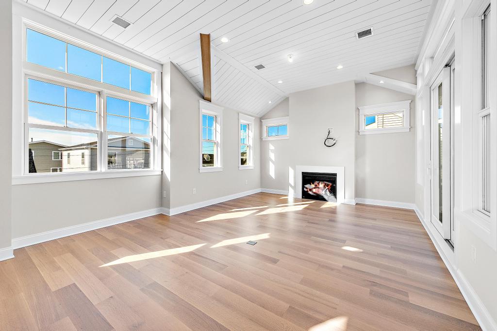 Interior image of an empty room with light walls and hardwood floors with a fireplace Renovations Contractor Interior JS Pro Construction Long Beach Island, NJ